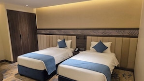 A hotel room with two beds, a wardrobe, and a carpeted floor. - Sedra Al Aalami Hotel (Madinah)