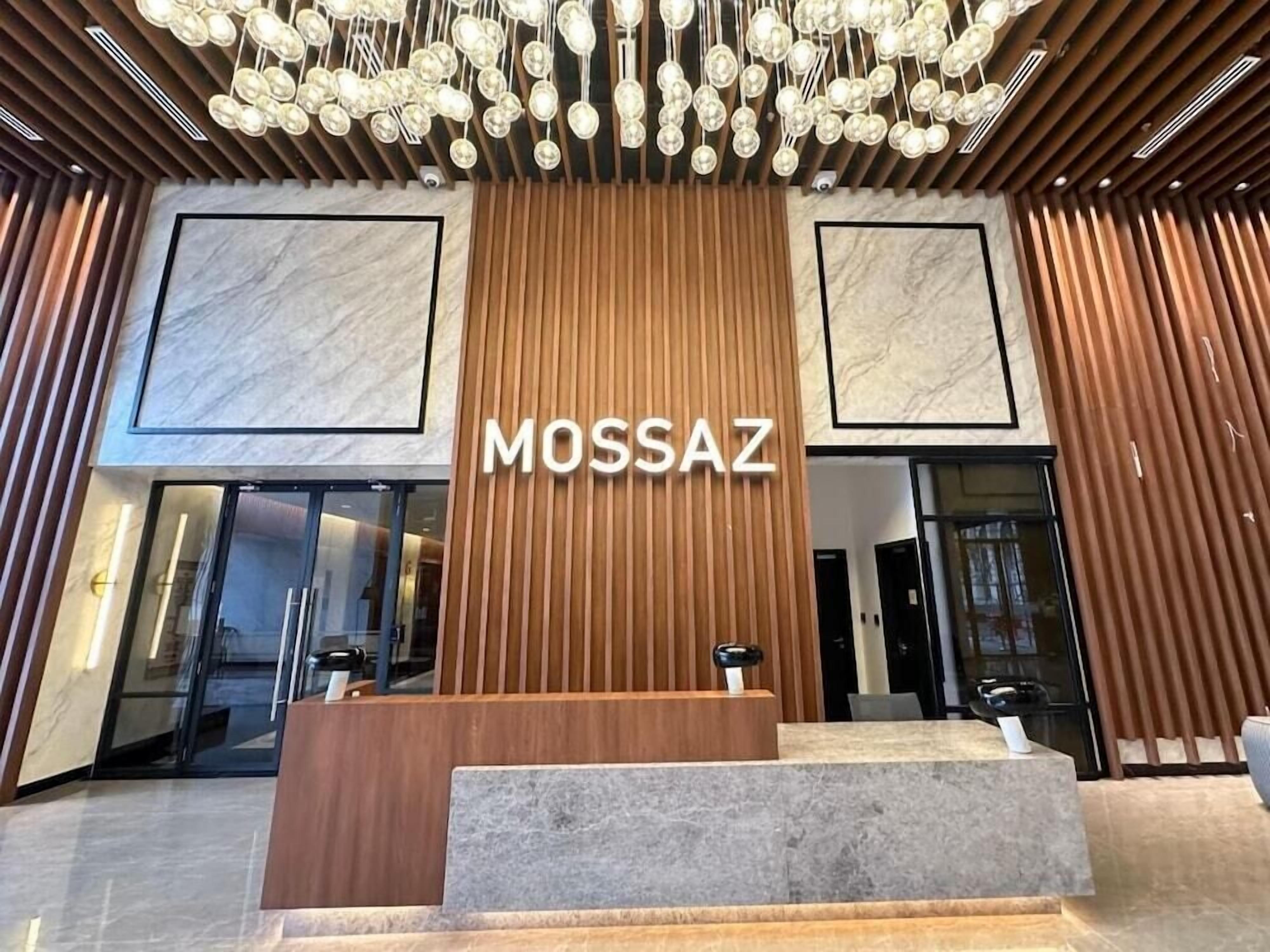 A reception area with a wooden desk and a marble wall.