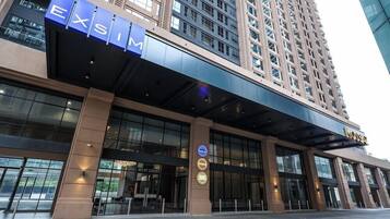 A hotel entrance with a prominent 'EXSIM' sign, a West Court sign, and a 'VOSS' sign above the entrance.