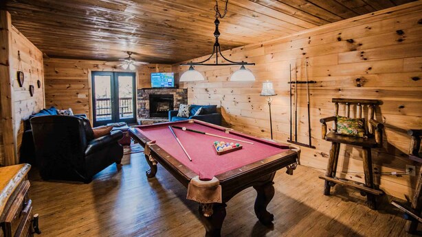 A wooden interior with a pool table, seating, and a fireplace. - Owls and Friends - 3 King Bedroom with ensuites-Hot tub-Pool Table (Blue Ridge)