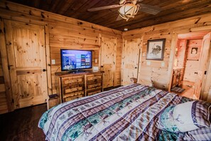 A wooden room with a bed, a television, and a ceiling fan. - Owls and Friends - 3 King Bedroom with ensuites-Hot tub-Pool Table (Blue Ridge)