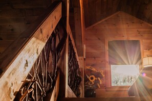 A wooden interior with a sloped ceiling, a window with a view of sunflowers, and a lamp. - Owls and Friends - 3 King Bedroom with ensuites-Hot tub-Pool Table (Blue Ridge)