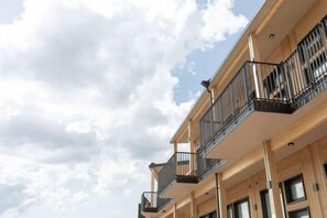 Un edificio de varios pisos con balcones y grandes ventanales.