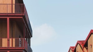 A multi-story building with balconies and a view of a green hill in the background. - Waterfront Cabins (Gothenburg)