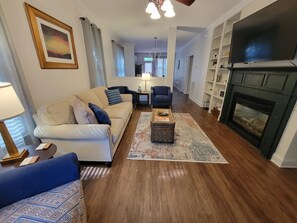 A living room with a sofa, armchairs, a coffee table, a fireplace, and a television. - Center of the action - Family and Pet Friendly (Apex)