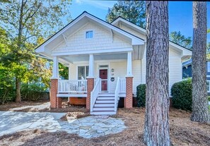 A two-story house with a front porch, a brick foundation, and a stone pathway leading to the entrance. - Center of the action - Family and Pet Friendly (Apex)