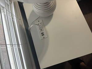 Pared blanca con un enchufe y sistema de organización de cables.