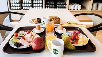 Ein Frühstücksbrett mit Eiern, Toast, Obst und Saft.