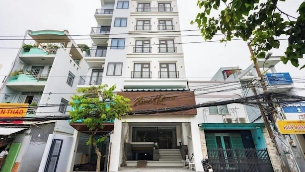 A multi-story building with a flat facade, balconies, and a visible entrance with steps. - Haven Hut Riverside (Ho Chi Minh City)