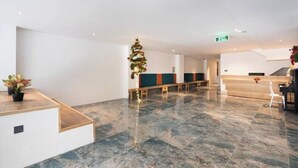 A hotel lobby with a reception desk, seating area, and a Christmas tree. - Haven Hut Riverside (Ho Chi Minh City)