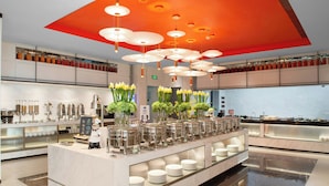 En modern buffé med en central ö, flera serveringsstationer och ett stort utbud av matbehållare.