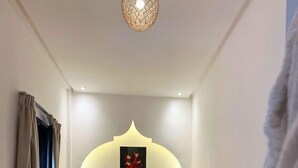 A bedroom with a bed, a headboard, a rug, and a window with curtains. - Riad El Khaeir Hammam & Spa (Marrakech)