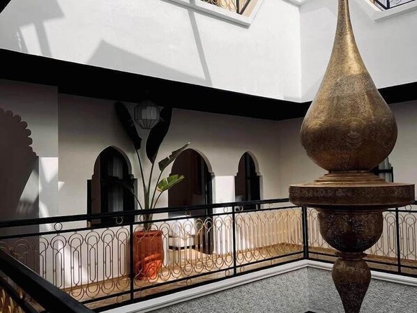 An interior courtyard with a fountain, a potted plant, and a railing. - Riad El Khaeir Hammam & Spa (Marrakech)