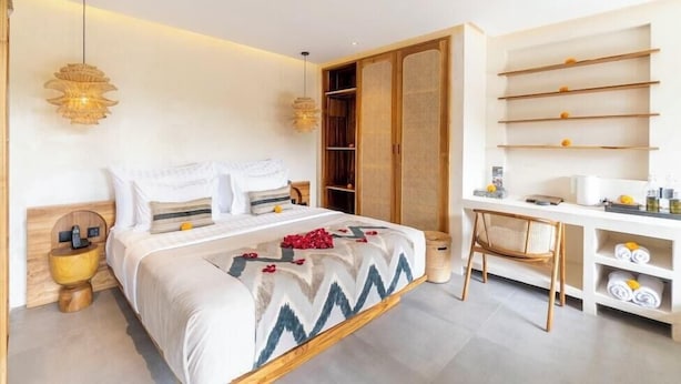 Ein modernes Hotelzimmer mit Bett, Nachttischen, Schreibtisch und Kleiderschrank.