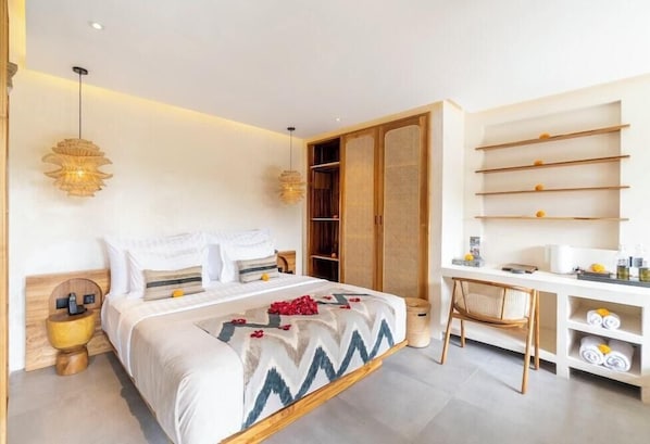 A modern hotel room with a bed, bedside tables, a desk, and a wardrobe.