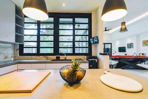 Une cuisine moderne dotée d’une grande fenêtre, d’une table de billard et d’un distributeur d’eau.