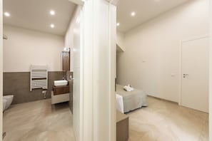 Ein modernes Badezimmer mit Badewanne, Toilette und Duschbereich.