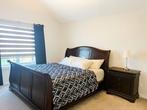 A bedroom with a bed, bedside table, and a window with blinds. - Elizabeth's Oasis Stylish 4 Bedroom Family Retreat Near West Edmonton Mall (Edmonton)