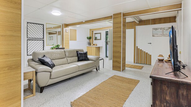 A modern living room with a sofa, coffee table, and a TV on a wooden stand. - Ocean Soul Unit 2 (Burnett Heads)