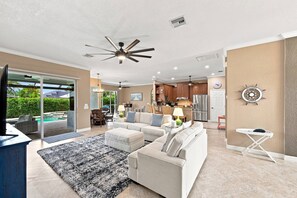 A spacious living area with a large sofa set, a dining area, and a kitchen. - Villa Cecilia | Spacious Cape Coral Escape | Private Heated Pool, Spa, Outdoor Living & Home Office (Cape Coral)
