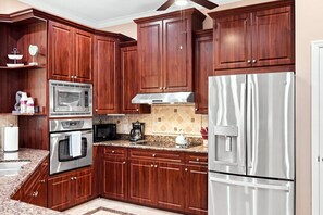 Eine Küche mit Holzausstattung, Edelstahlgeräten und einer Arbeitsplatte aus Granit.