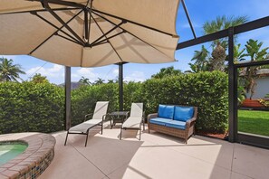 An outdoor patio with a pool, lounge chairs, a sofa, and a large umbrella. - Villa Cecilia | Spacious Cape Coral Escape | Private Heated Pool, Spa, Outdoor Living & Home Office (Cape Coral)