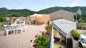 A terrace with outdoor furniture, a staircase, and a view of a hill with a church. - 3 bedroom nice apartment in Conca Casale (Conca Casale)