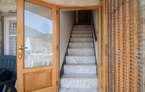 Eine Holztür mit einem Glasschieber, die zu einer Marmortreppe führt.
