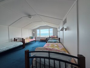 A dormitory room with two beds, a window, and a view of the sea. - Best location with sea views. Enjoy the simple beach life with close amenities. (Victor Harbor)