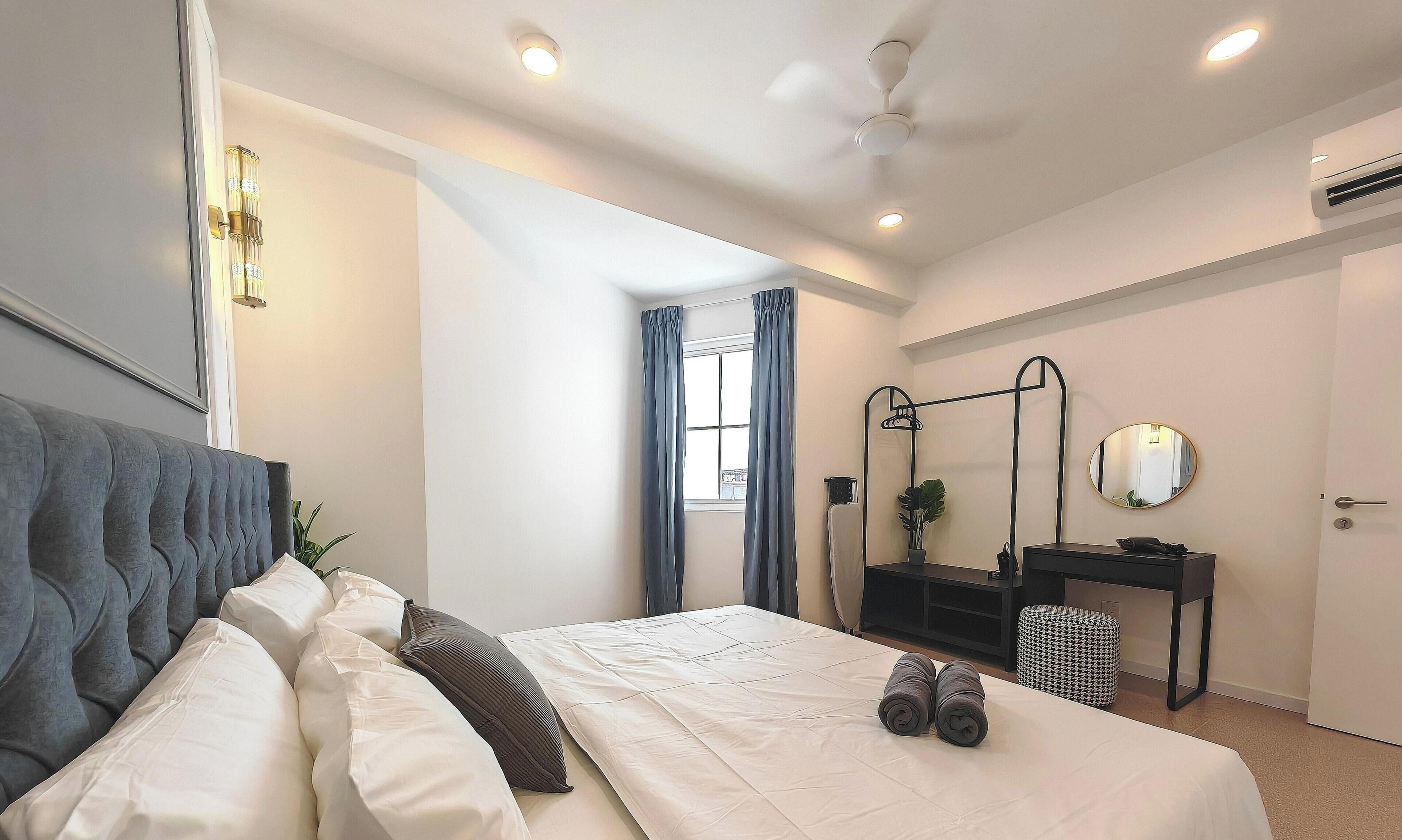 Une chambre moderne avec un lit, une table de chevet, un miroir et une fenêtre avec des rideaux.
