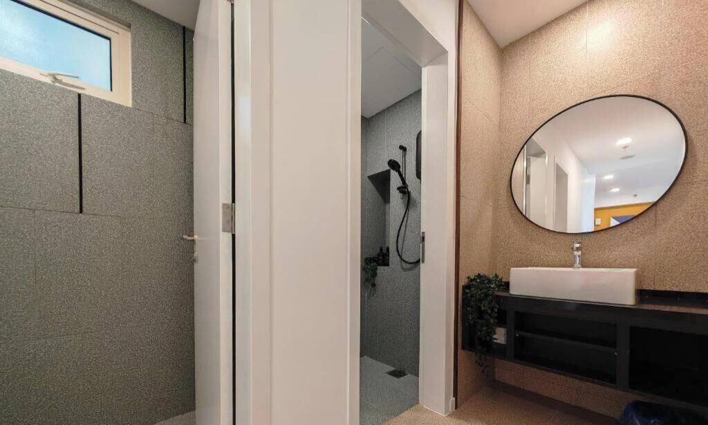 A bathroom with a shower, a sink, and a mirror.