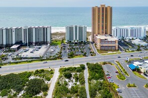 A coastal hotel complex with multiple high-rise buildings, parking areas, and a road leading to the beach. - Tidewater 608 | Indoor/Outdoor Pools + Hot Tub, Fitness & Sauna (Orange Beach)