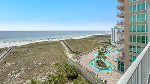 Resort com vista para a praia, área de piscina e calçadão.