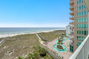 A resort with a beach view, a pool area, and a boardwalk. - Tidewater 608 | Indoor/Outdoor Pools + Hot Tub, Fitness & Sauna (Orange Beach)