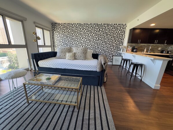 A modern living room with a sofa, a coffee table, and a patterned rug.
