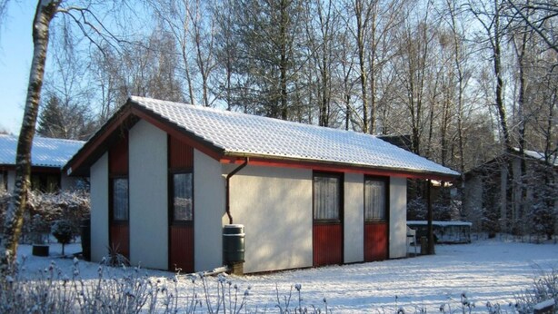 A small, single-story building with a sloped roof, surrounded by snow-covered ground and trees. - Beautiful Bungalow in Nature (Getelo)