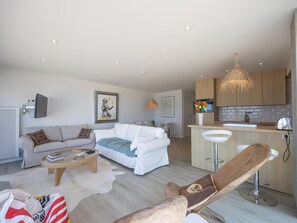 Ein modernes Wohnzimmer mit einer Couch, einem Couchtisch und einem Essbereich mit Bar.