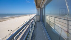 A balcony with a view of a beach and a parking area. - Three-bedroom apartment with sea view (Middelkerke)