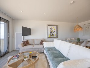 Ein modernes Wohnzimmer mit Sofa, Couchtisch und Kunstwerk an der Wand.