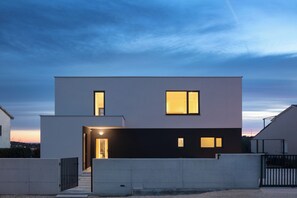 A modern two-story house with a flat roof, a visible entrance, and a gated driveway. - Villa Sealine - Pool & Garden (Medulin)