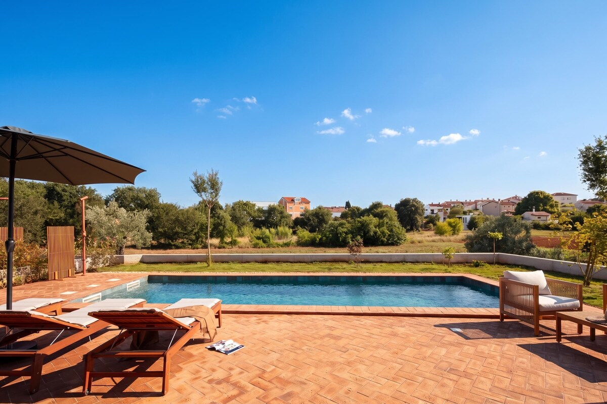 A swimming pool with lounge chairs and a pergola on a sunny day.