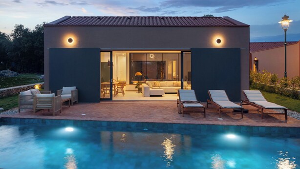 Uma casa moderna com piscina, área de estar ao ar livre e interior bem iluminado.