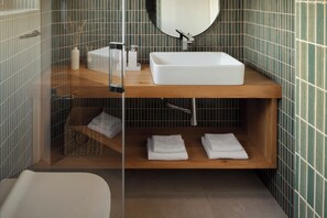 A modern bathroom with a rectangular sink, a mirror above it, and a wooden shelf below. - Case Atrio Villas (Rovinj)