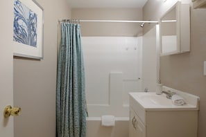Un baño con bañera, lavamanos y ducha.