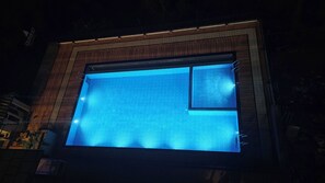 Piscina rectangular con estructura de madera y un pequeño ventanal en un lateral.
