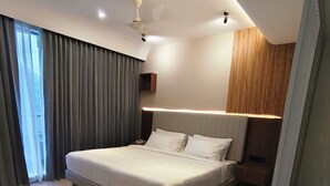 A modern bedroom with a large bed, a ceiling fan, and a view of the outdoors. - AURA 42 BY DIMORA (Devikolam)