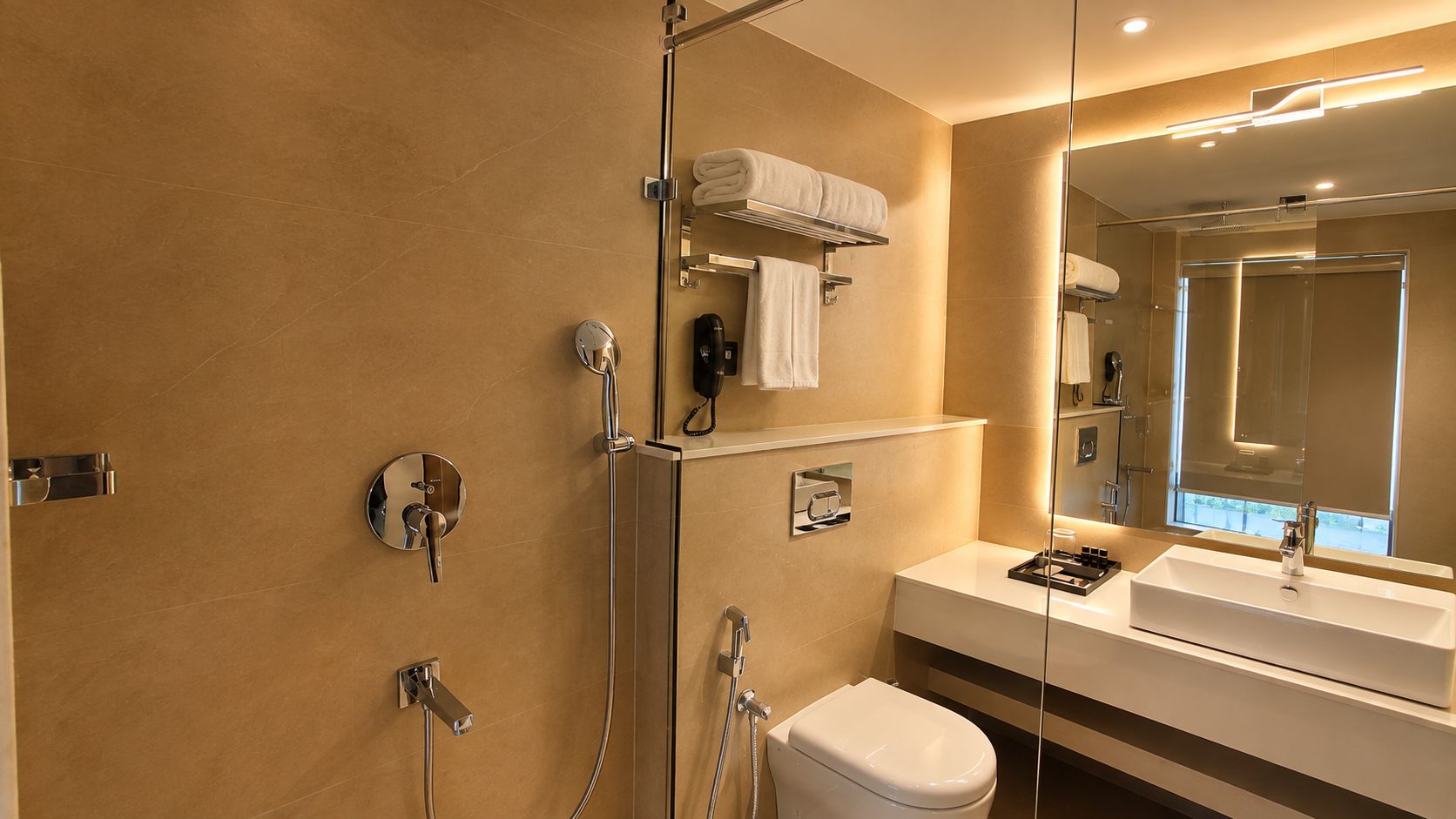 Un baño moderno con cabina de ducha de vidrio, inodoro, lavabo y espejo.