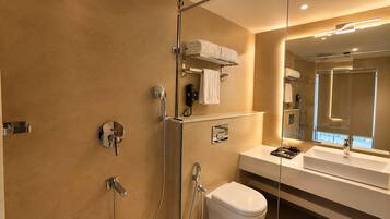 Un baño moderno con cabina de ducha de vidrio, inodoro, lavabo y espejo.