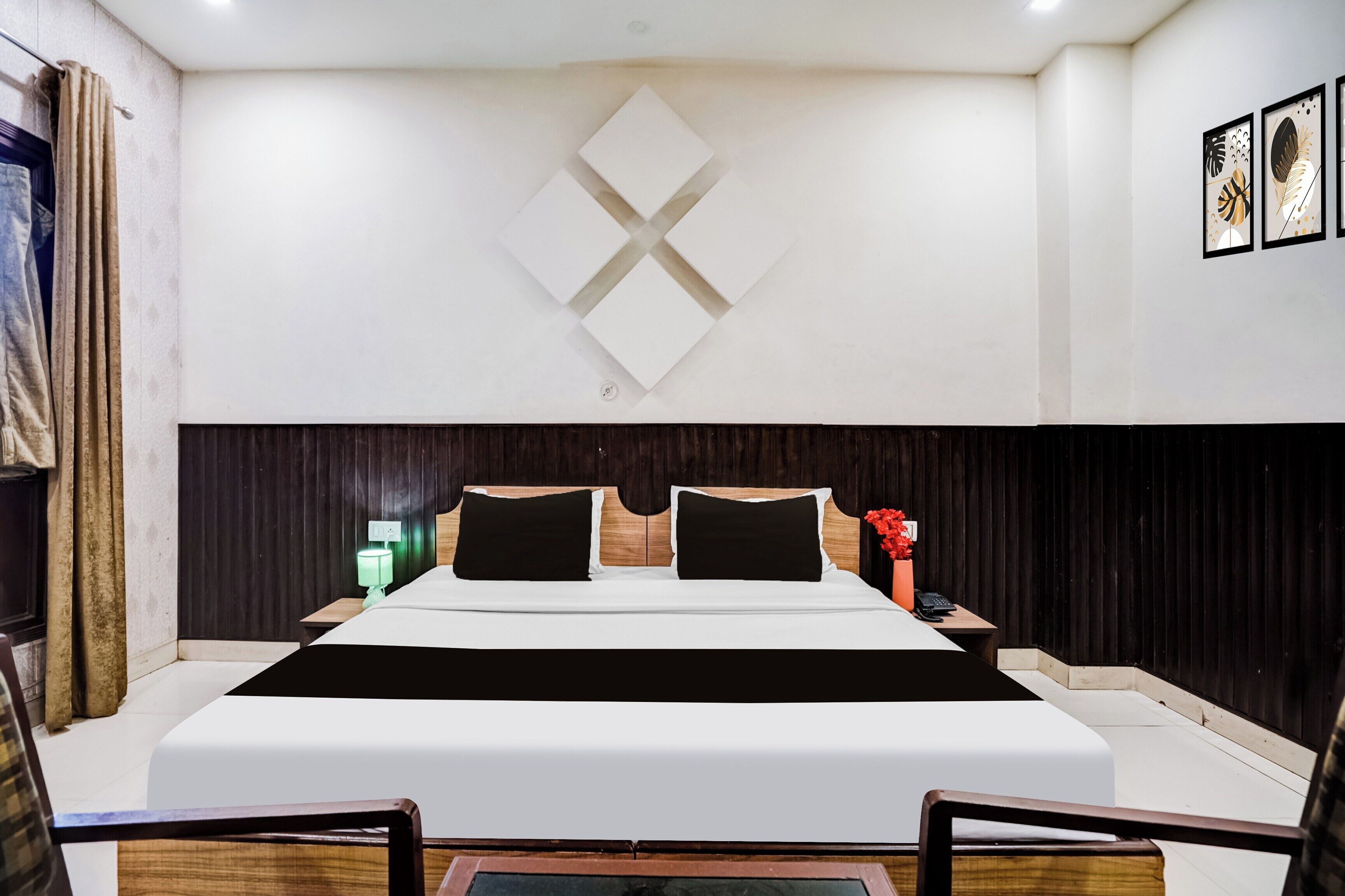 Una camera d'albergo moderna con un letto grande, una testiera in legno e un'opera d'arte appesa al muro.