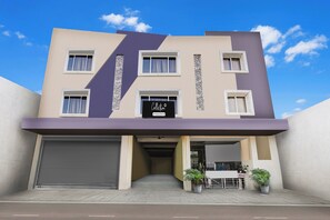 Un edificio moderno con fachada plana, varias ventanas y señalización de empresa.